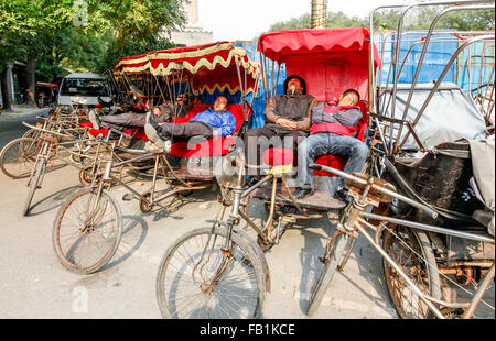 Les conducteurs de pousse-pousse à une pause après la prise d'une tournée dans la région des lacs Houhai Beijing Chine Banque D'Images