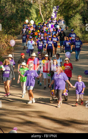 Les participants à un événement de collecte de fonds de bienfaisance pour les victimes d'Alzheimer à pied dans une Laguna Niguel, CA, Parc. La note mauve T-Shirts commémoratifs accordés pour les dons. Banque D'Images