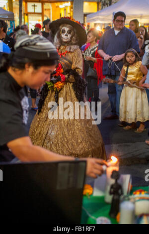 Avec un squelette en costume visage, la Calavera Catrina ('Dapper Skeleton') s'allume un cierge à la memorial autels pendant le Jour des Morts ou Dia de muertos cérémonies chez les Hispaniques à Santa Ana, CA. La maison de vacances se concentre sur des rassemblements de famille et amis pour prier Banque D'Images