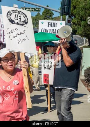 Grève des travailleurs de l'union multiraciale électrique piquet un gouvernement américain en construction Laguna Niguel, CA, pour protester contre l'absence d'augmentations salariales prévues. Quai de chargement fédérale Note signer en arrière-plan et l'organisateur ne bull horn. Banque D'Images