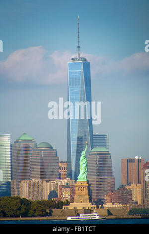 La Statue de la liberté sur Liberty Island à New York Harbor est juxtaposée avec One World Trade Center, vue de Jersey City, New Jersey. Remarque Bateau de tourisme. Banque D'Images