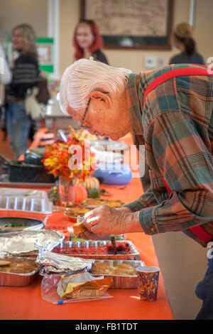 Un vieil homme fait un buffet repas sélection au Silverado, CA, centre communautaire est gratuit pour les habitants de repas-partage de l'action de grâce. Les dindes et les jambons ont été fournies par le centre et d'autres plats ont été donnés par des bénévoles. Banque D'Images