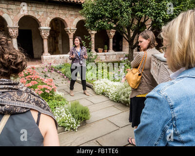 Un guide explique un jardin d'herbes médicinales au Cloisters Museum de Fort Tryon Park, New York City, partie du Metropolitan Museum of Art. remarque l'architecture médiévale. Banque D'Images