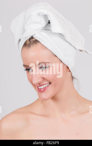 Belle femme après la douche avec blanc serviette enroulée sur la tête. Banque D'Images