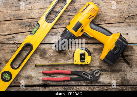 Outils de construction sur fond de bois. Niveau, tournevis ou percer, bande et spanner haut voir l'image Banque D'Images