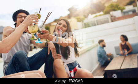 Happy young people toasting cocktails dans une partie sur le toit. Les jeunes amis et prendre un verre. Banque D'Images