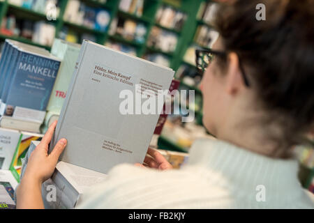 Munich, Allemagne. 8 janvier, 2016. ILLUSTRATION - vendeur livre Katzlinger Marie prend le premier des deux volumes de l'édition annotée de 'Hitler, Mein Kampf - une édition critique' dans sa main dans le Lehmkuhl bookshop . L 'Institut fuer Zeitgeschichte" (Institut pour l'histoire contemporaine) présente le jour de la publication, l'édition annotée de l'original 1924 publication de la brochure inflammatoire 'Mein Kampf', écrit par Adolf Hitler national-socialiste. Dpa : Crédit photo alliance/Alamy Live News Banque D'Images