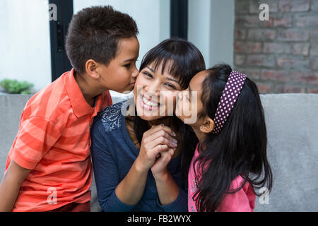 Mère heureuse d'être embrassé par ses enfants Banque D'Images