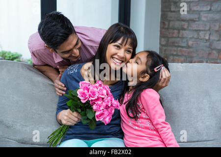Happy mother holding roses d'être embrassé par sa fille Banque D'Images