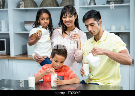 Heureux en famille manger des biscuits et boire du lait Banque D'Images