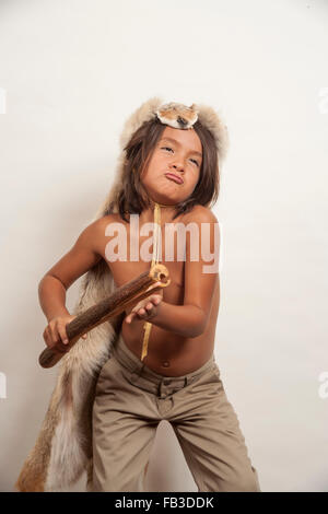Un garçon américain membre de la tribu Acjachemen joue le battant bâton, un instrument de musique à percussion primitive. Remarque la tête de coyote pour costume homme membres tribaux.modèle libération communiqué de modèle Banque D'Images