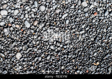 Petits rochers basaltiques qui forment le long des plages de sable noir de la côte islandaise populaires près de Vik. Banque D'Images