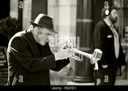 BATH, Somerset, Royaume-Uni - 12 septembre 2015 Homme jouant de la trompette dans la rue, ignoré par l'homme au casque Banque D'Images