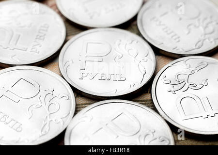 Plusieurs pièces de métal de valeur d'un rouble russe qui reposent sur l'argent de papier Banque D'Images