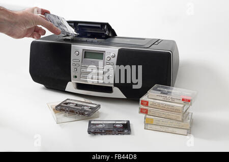 Une cassette enregistrée est chargé dans un style des années 1990, radio cassette et CD et DVD. Empilées les bandes à l'avant-plan. Banque D'Images