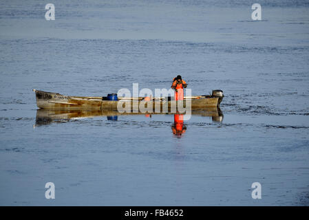 Berlin, Allemagne. Jan 9, 2016. Un pêcheur apporte dans un filet maillant entre la glace mince feuilles sur le lac de Wannsee à Berlin, Allemagne, le 9 janvier 2016. PHOTO : RALF HIRSCHBERGER/DPA/Alamy Live News Banque D'Images