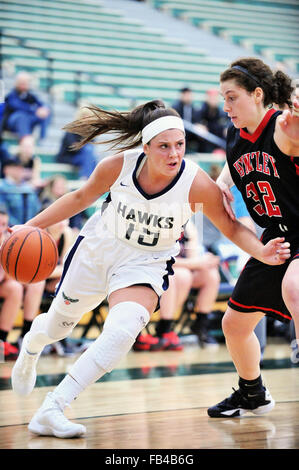 Dvd la protection de la balle comme elle entraîne le départ vers son adversaire panier au cours d'un match de basket-ball de l'école secondaire. USA. Banque D'Images