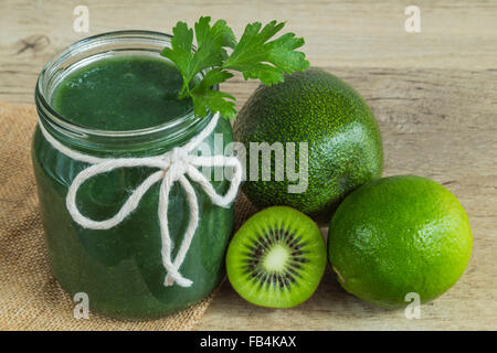 Smoothie vert dans un pot de confiture avec des ingrédients Banque D'Images