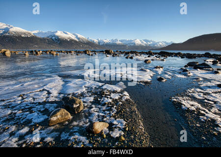 Plage de glace près de Haines en Alaska avec des blocs de glace et de neige sur une marée descendante avec ciel bleu. Banque D'Images