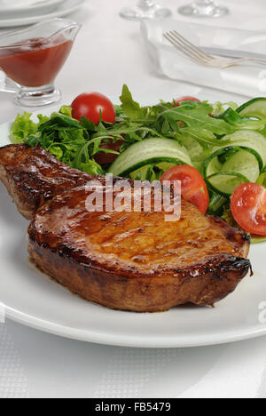 Steak frites sur l'os avec des légumes et de ketchup Banque D'Images