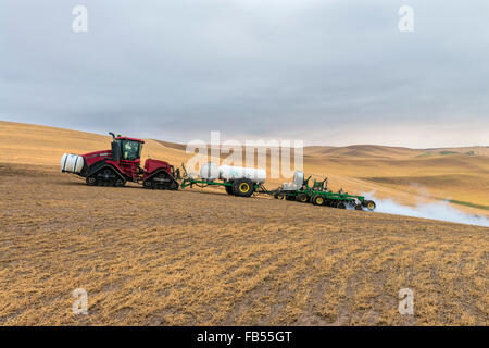 Cas tracteur Quadtrac extraction d'un réservoir d'ammoniac anhydre et l'application de l'applicateur d'anhydre un champ à l'avance de la préparation Banque D'Images