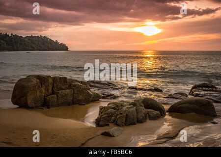 Coucher de soleil sur une plage rocheuse en Thaïlande Banque D'Images