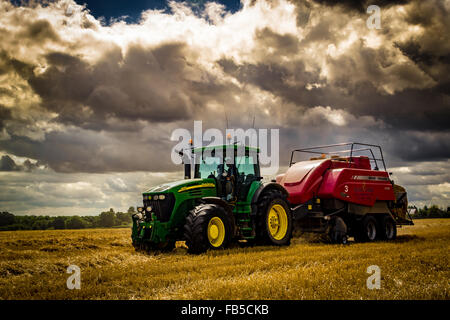 Tracteur John Deere et presse Massey Ferguson pour la mise en balles de balles de paille Banque D'Images