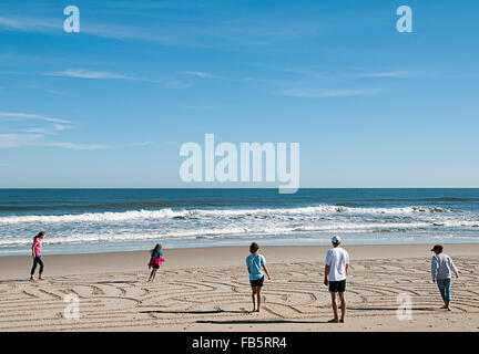 Une famille passant par un labyrinthe de plage sur la plage, dans les Outer Banks de Caroline du Nord. Banque D'Images