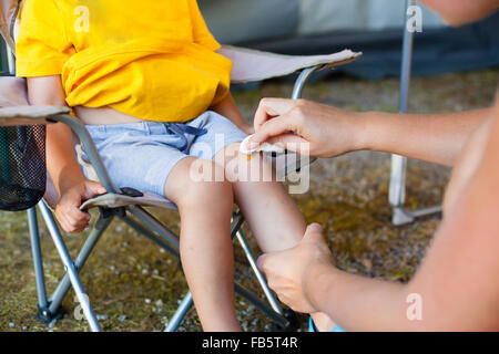 Mère traite son fils genou écorché (shallow dof). Banque D'Images