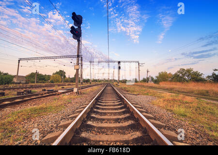 Plate-forme du train et au feu de circulation au coucher du soleil. Railroad. La gare ferroviaire. Banque D'Images