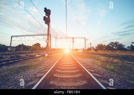 Plate-forme du train et au feu de circulation au coucher du soleil. Railroad. La gare ferroviaire. Banque D'Images