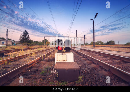 Plate-forme du train et au feu de circulation au coucher du soleil. Railroad. La station de chemin de fer Banque D'Images