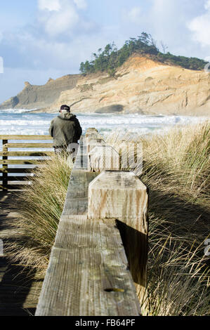 Un homme observe le surf sur la plage d'un belvédère, Pacific City, Oregon Banque D'Images