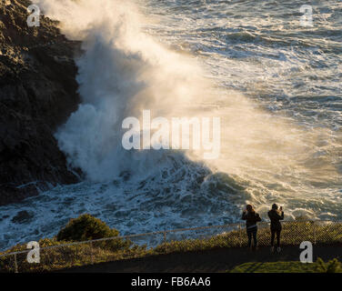 Florance, Oregon, USA. 10 janvier, 2016. Regarder les touristes comme de grandes vagues crash à un affleurement rocheux sous le Heceda Head Lighthouse le long de la côte du Pacifique de l'Oregon, près de Florence. Le National Weather Service a émis un avis de surf du dimanche au milieu de semaine pour centrale de la côte de l'Oregon. © Robin/Loznak ZUMA Wire/Alamy Live News Banque D'Images