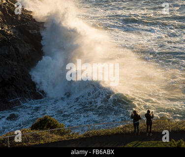 Florence, Oregon, USA. 10 janvier, 2016. Regarder les touristes comme de grandes vagues crash à un affleurement rocheux sous le Heceda Head Lighthouse le long de la côte du Pacifique de l'Oregon, près de Florence. Le National Weather Service a émis un avis de surf du dimanche au milieu de semaine pour centrale de la côte de l'Oregon. © Robin/Loznak ZUMA Wire/Alamy Live News Banque D'Images