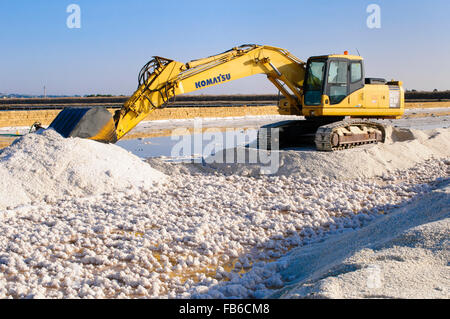 Italie, Sicile, Trapani. Une pelle sur chenilles Komatsu la récolte du sel de mer à partir d'un bassin d'évaporation. Banque D'Images