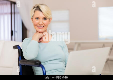 Portrait of senior woman handicapés à la maison à l'aide d'ordinateur portable Banque D'Images