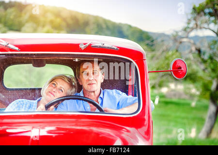 Senior couple in red car Banque D'Images