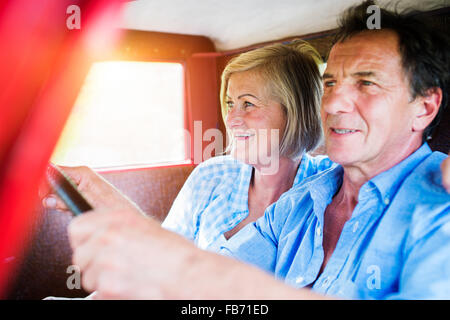 Senior couple in red car Banque D'Images