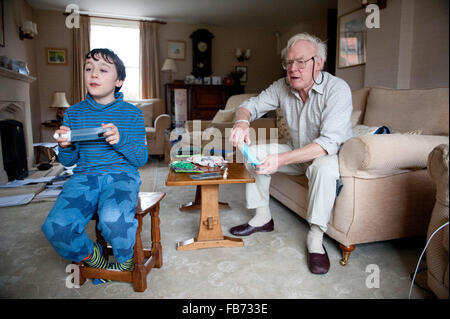 Petit-fils de 11 ans de jouer sur la wii avec son grand-père dans le Yorkshire du Nord Banque D'Images