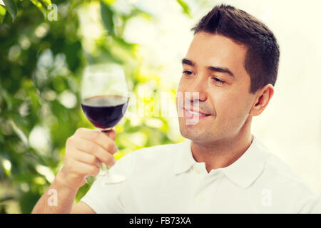 Homme heureux de boire le verre de vin rouge Banque D'Images