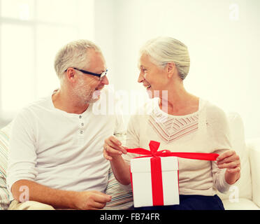 Happy senior couple with gift box à la maison Banque D'Images