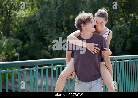 Young man giving woman piggyback ride Banque D'Images