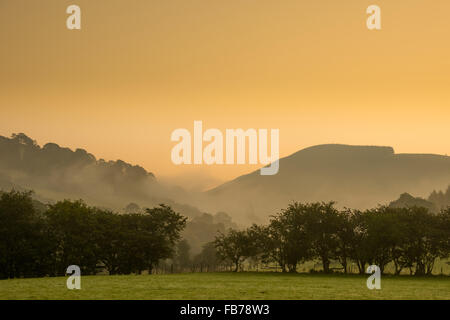 Le brouillard roulant sur les collines au lever du soleil dans le parc national de Snowdonia North Wales UK Banque D'Images