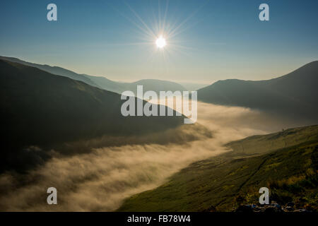 Lever du soleil dans le parc national de Snowdonia avec brouillard roulant à travers la vallée le long de la route dans le Nord du Pays de Galles UK Banque D'Images