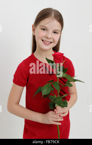 Petite fille et roses rouges Banque D'Images