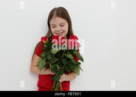 Petite fille et rose rouge Banque D'Images