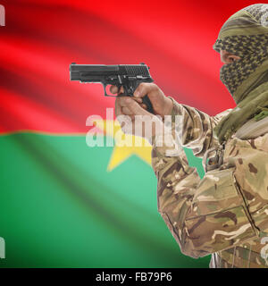 L'homme avec l'arme à la main et drapeau national sur fond de série - Burkina Faso Banque D'Images