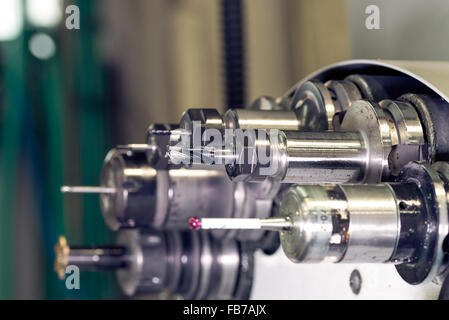 La rotation de la tête avec la machine de forage bits et des outils dans une usine de mécanique de haute précision à tour CNC en atelier Banque D'Images