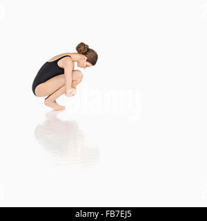 Side view of woman in teddy crouching over white background Banque D'Images